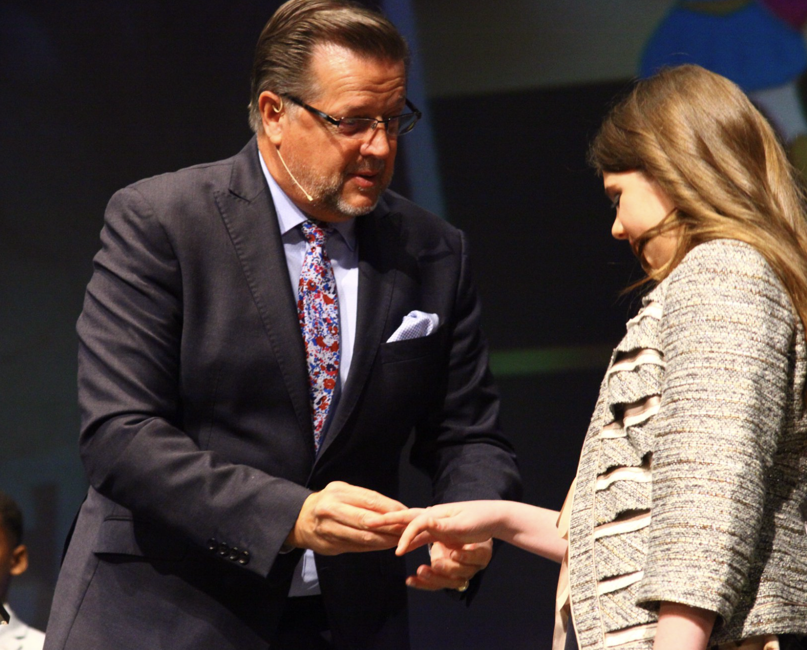 girl trading a toy for a ring during unoffendables graduation.