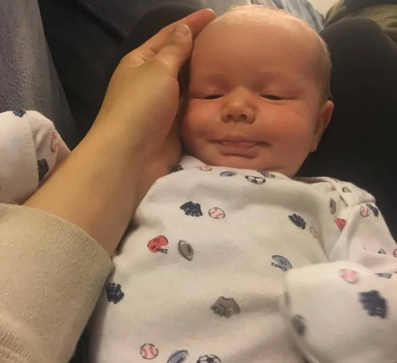 Baby in nursery being held.